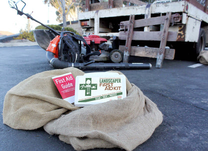 Landscaper's First Aid Kit 103 Piece, Plastic Case displayed with First Aid Guide on landscaping site.