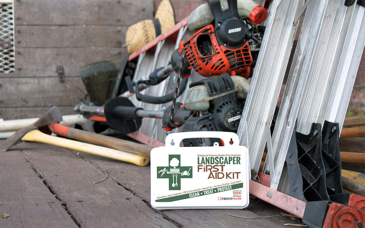 Landscaper's First Aid Kit 103 Piece, Plastic Case displayed next to gardening tools on a wooden surface.