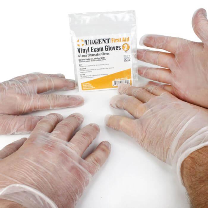 hands wearing medical gloves on table featuring Large Disposable Gloves 2 Pair Per Bag Urgent First Aid®